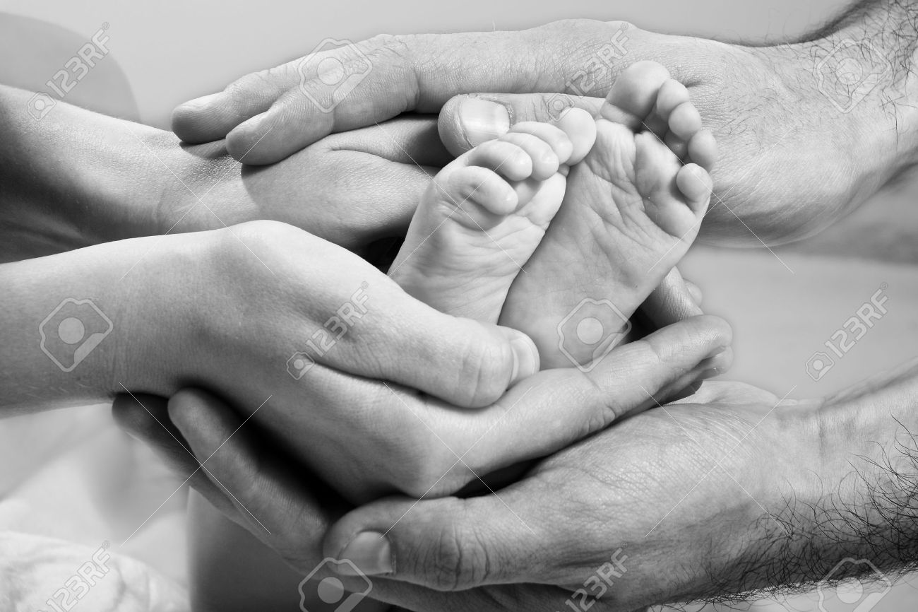 31682602-newborn-baby-feet-on-parents-hands-stock-photo
